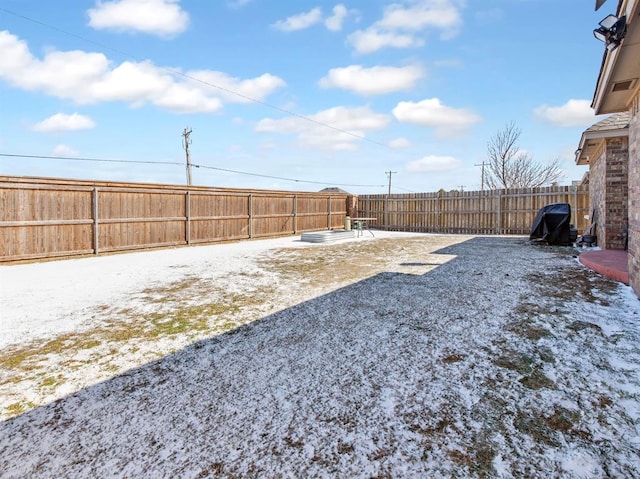 yard covered in snow with a fenced backyard