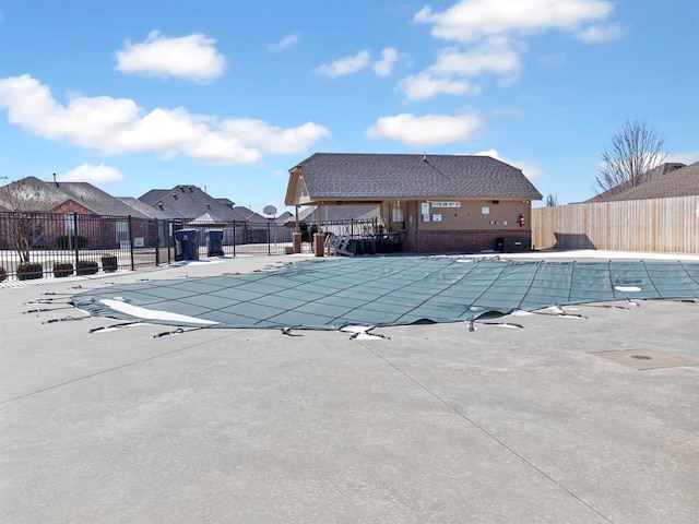 community pool with a patio and fence