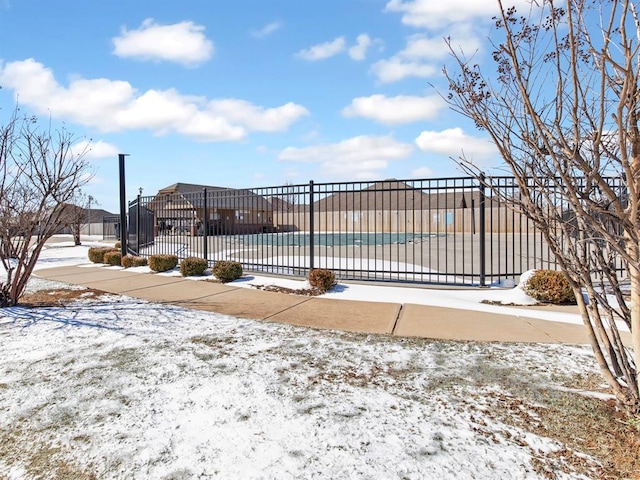 snow covered pool featuring fence