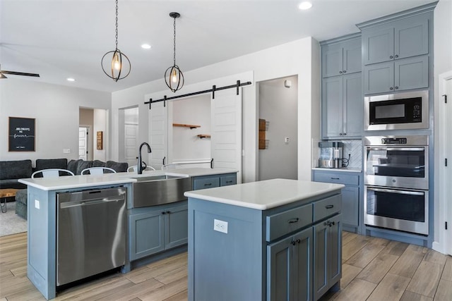 7201 SW 122nd St, Oklahoma City, OK 73173 - kitchen featuring stainless steel appliances, light wood-type flooring, a center island, and a sink
