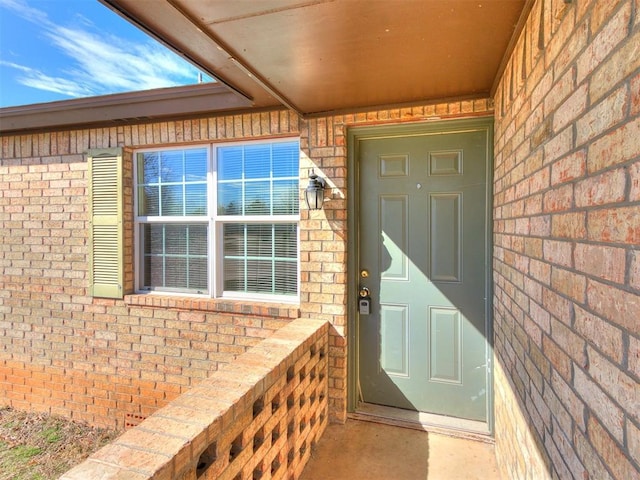 view of exterior entry featuring brick siding