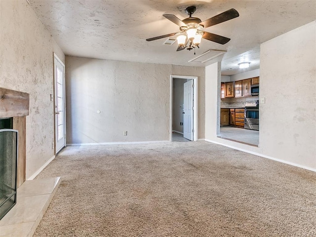 unfurnished living room with a fireplace, visible vents, a ceiling fan, light carpet, and baseboards