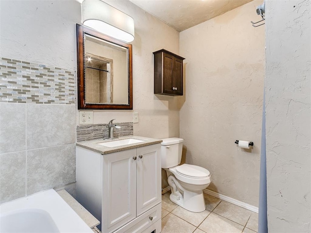 bathroom with a shower, a textured wall, toilet, vanity, and tile patterned floors