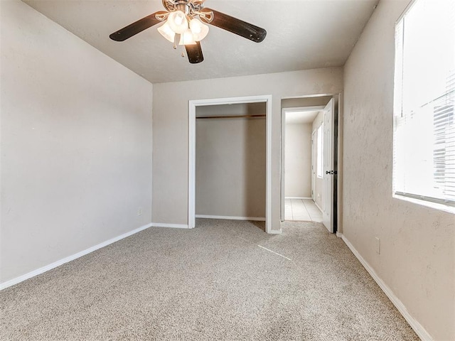 unfurnished bedroom with ceiling fan, carpet floors, a closet, and baseboards