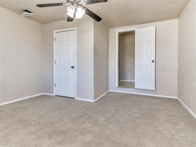 unfurnished bedroom with ceiling fan, carpet floors, visible vents, and baseboards