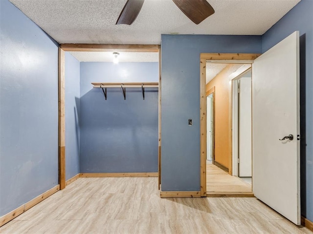 unfurnished bedroom with a textured ceiling, wood finished floors, and a ceiling fan