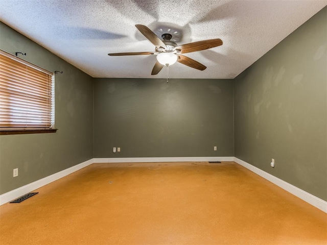 empty room featuring ceiling fan, baseboards, and a textured ceiling