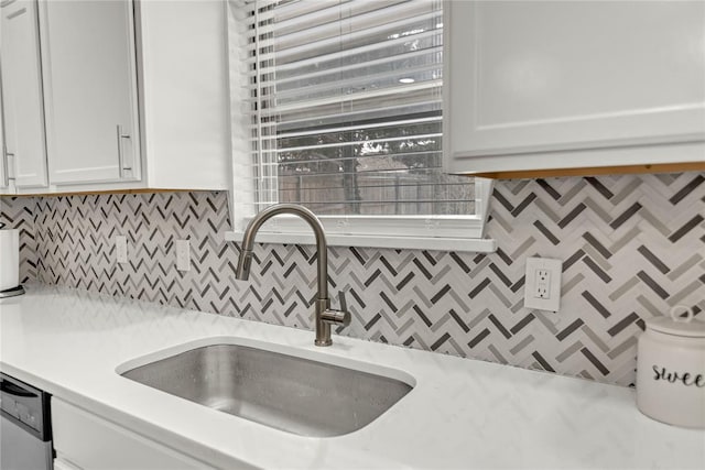 kitchen with dishwasher, light countertops, a sink, and white cabinets