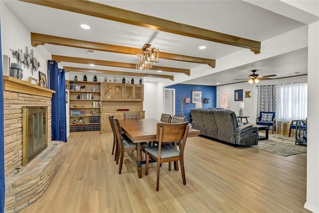 dining area with recessed lighting, a fireplace, visible vents, light wood-type flooring, and beamed ceiling