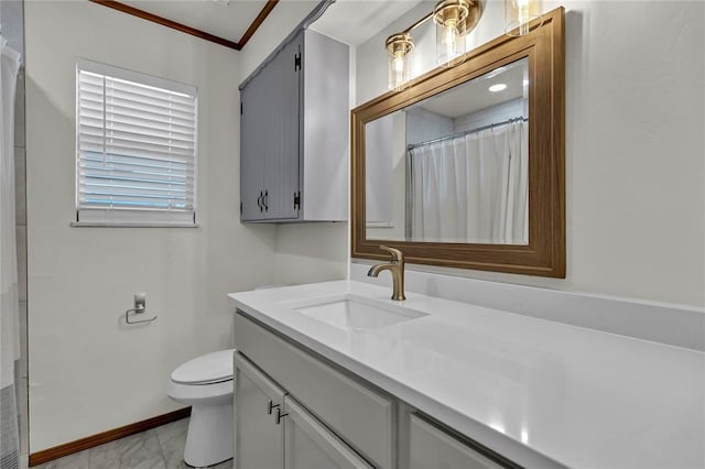 bathroom with toilet, baseboards, ornamental molding, and vanity