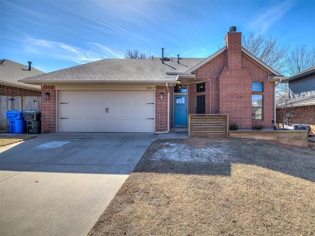 single story home featuring concrete driveway, brick siding, a chimney, and an attached garage