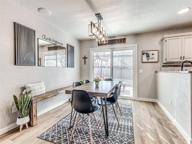 dining area featuring plenty of natural light, a textured ceiling, and a textured wall