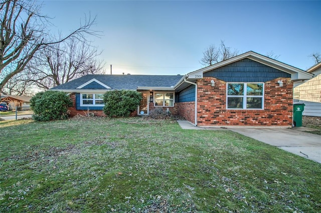 single story home featuring a front yard and brick siding