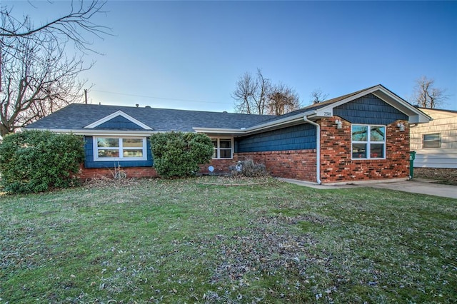 ranch-style home with a shingled roof, brick siding, and a front lawn