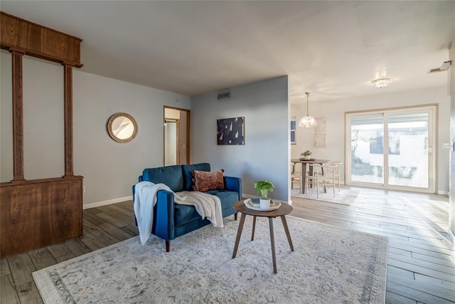 living room with visible vents, hardwood / wood-style flooring, and baseboards