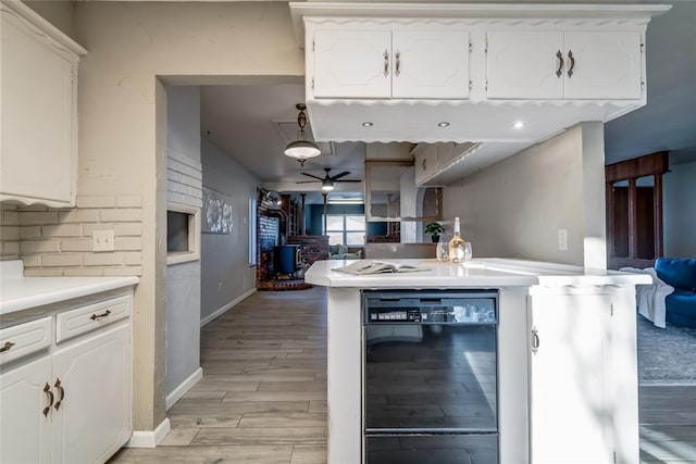 kitchen with light wood-style floors, light countertops, white cabinets, and a ceiling fan