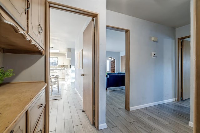 corridor featuring wood tiled floor and baseboards