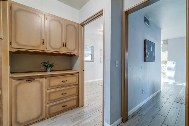 corridor featuring baseboards, visible vents, and wood tiled floor