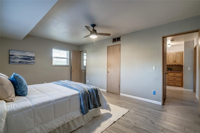 bedroom with visible vents, ceiling fan, light wood-style flooring, and baseboards