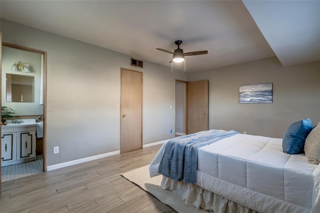 bedroom with visible vents, a ceiling fan, ensuite bath, wood finished floors, and baseboards