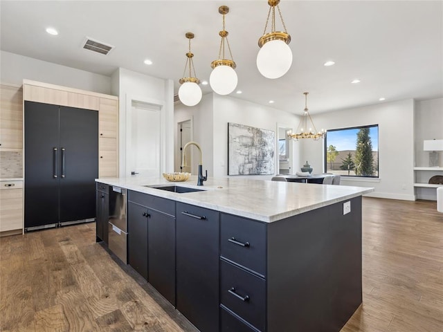 kitchen with visible vents, an island with sink, dark wood-style flooring, a sink, and built in fridge