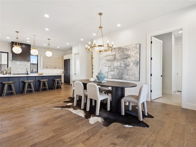 dining space with light wood-style floors, a chandelier, and recessed lighting