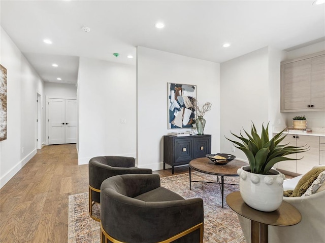 living area with baseboards, recessed lighting, and light wood-style floors