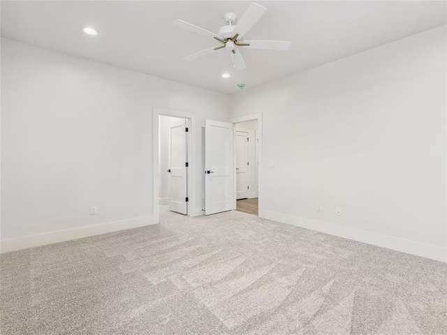 empty room featuring light carpet, recessed lighting, a ceiling fan, and baseboards