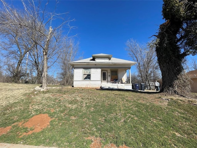 exterior space with metal roof, a yard, and a porch