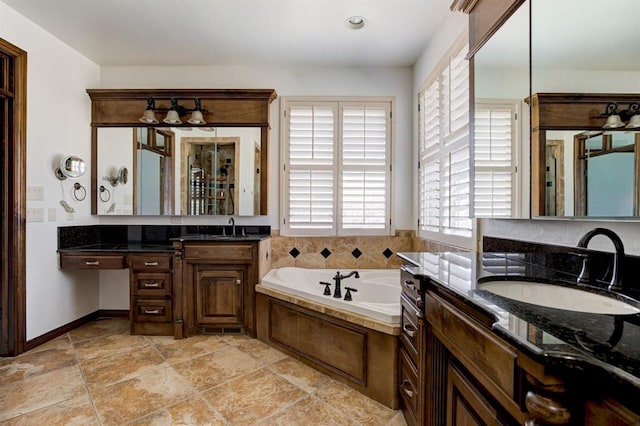 full bathroom featuring two vanities, a garden tub, and a sink