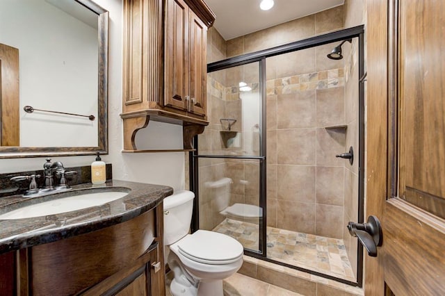 full bathroom featuring a shower stall, toilet, and vanity