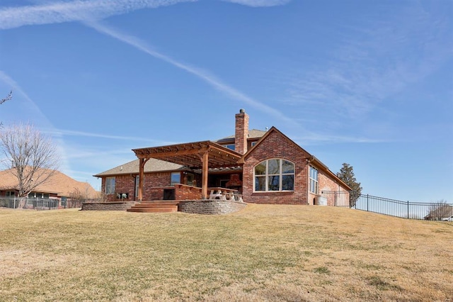 back of house with a pergola, brick siding, a yard, and fence