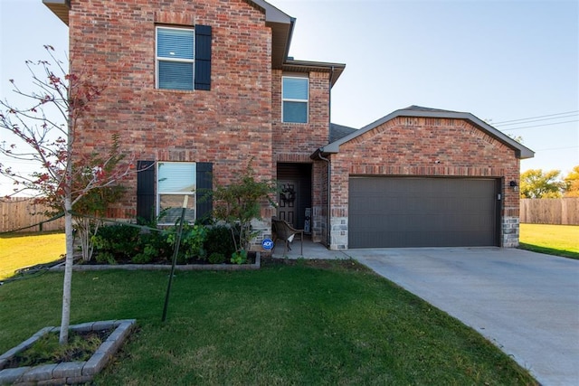 traditional-style house with brick siding, concrete driveway, fence, a garage, and a front lawn