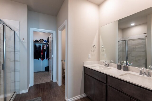 bathroom featuring double vanity, a stall shower, and a sink