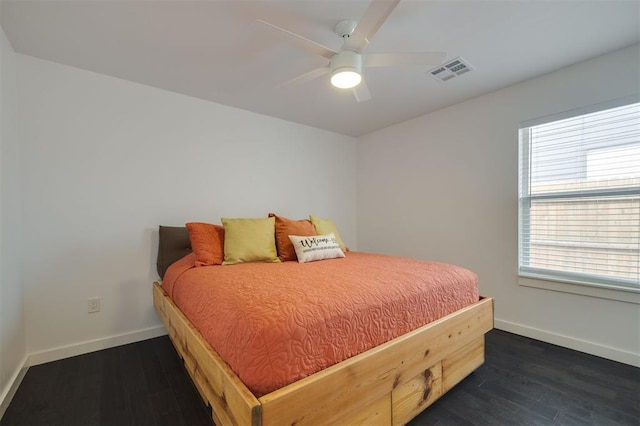 bedroom featuring dark wood-type flooring, visible vents, baseboards, and a ceiling fan