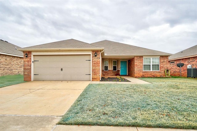 single story home featuring brick siding, concrete driveway, a front yard, central AC, and a garage