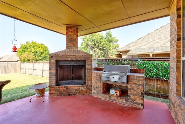 view of patio / terrace featuring a grill, an outdoor kitchen, a fenced backyard, and an outdoor brick fireplace