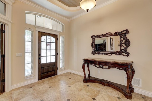 foyer entrance with baseboards, visible vents, and crown molding