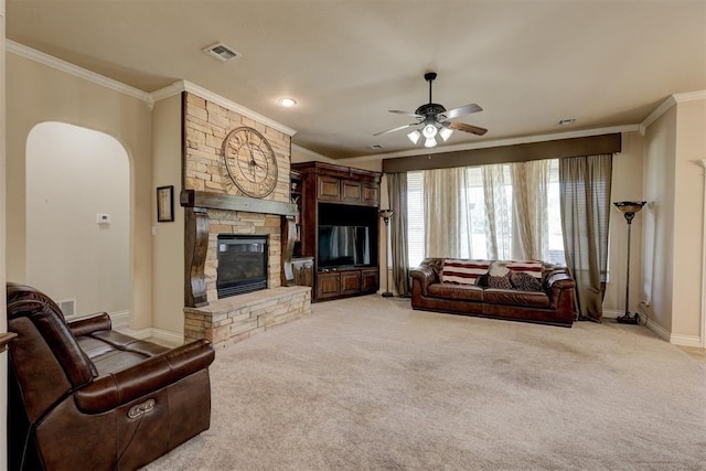 living room with ornamental molding, a fireplace, visible vents, and light colored carpet