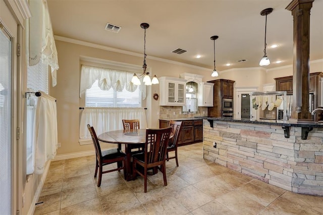 dining room featuring visible vents, crown molding, and baseboards