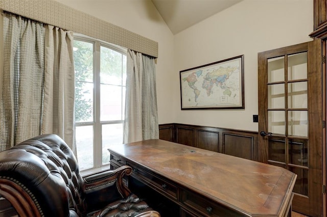 office with a wainscoted wall, plenty of natural light, and vaulted ceiling