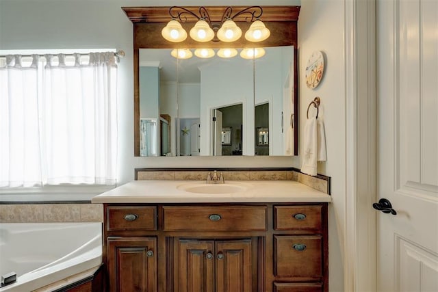 full bathroom featuring ornamental molding, a garden tub, and vanity