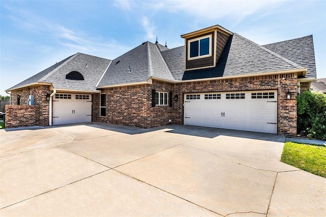 view of front of house featuring a garage, roof with shingles, concrete driveway, and brick siding