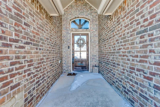 doorway to property featuring brick siding