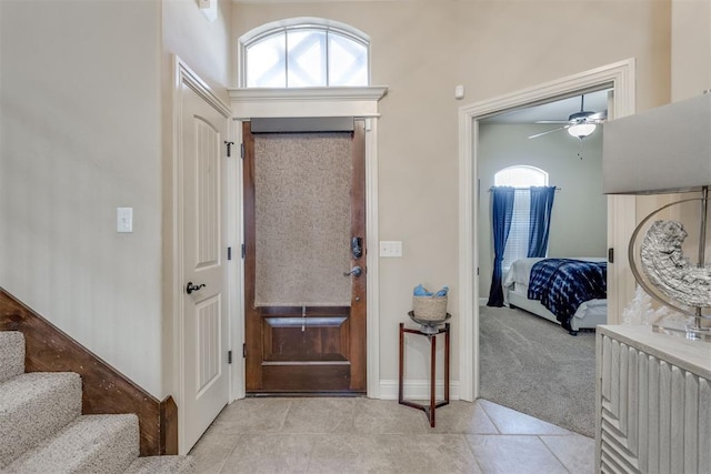 entrance foyer featuring light carpet, light tile patterned floors, and stairway