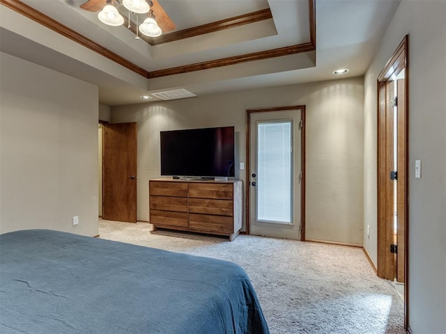 bedroom with light carpet, a tray ceiling, visible vents, and crown molding