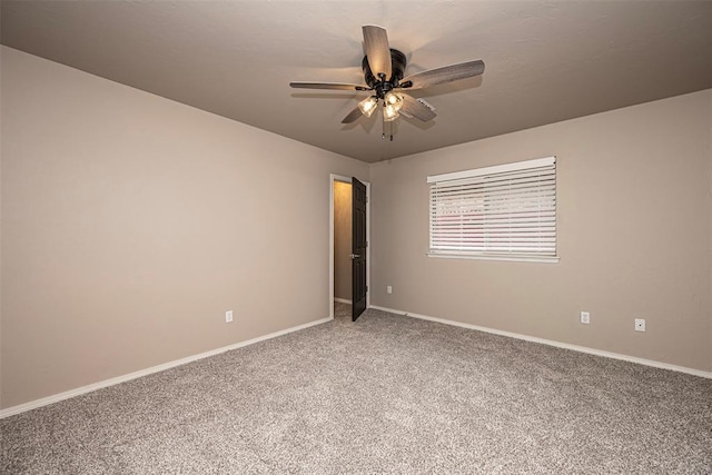 carpeted empty room featuring ceiling fan and baseboards