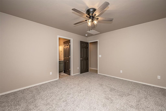 unfurnished bedroom featuring carpet floors, visible vents, ensuite bathroom, a ceiling fan, and baseboards