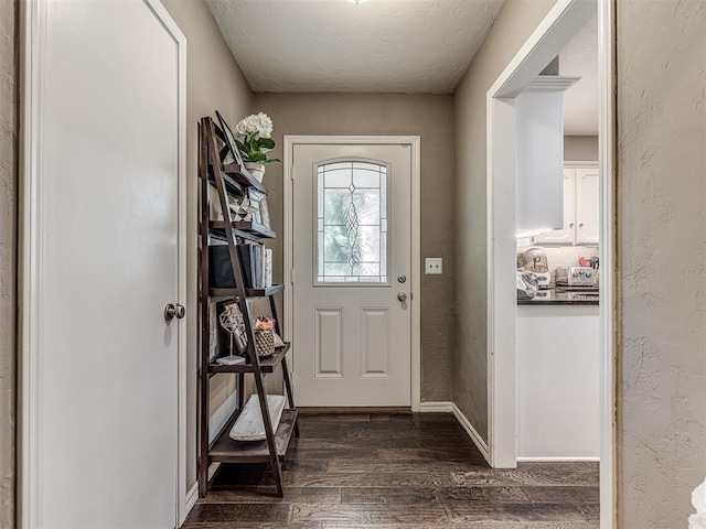 entryway with dark wood-type flooring, a textured wall, a textured ceiling, and baseboards