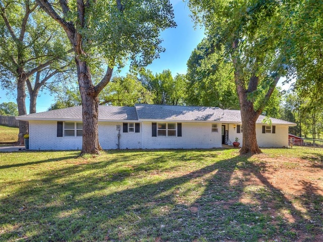 back of property featuring brick siding and a lawn